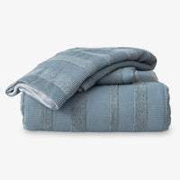 Folded blue textured towels on a white background
