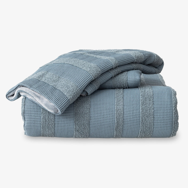 Folded blue textured towels on a white background