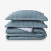 Stack of blue striped bedding on a white background