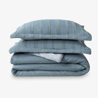 Stack of blue striped bedding on a white background
