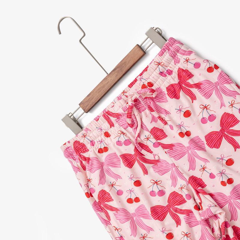 Krissy Mast printed lounge pants laid flat with a hanger on a white surface.