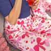Person wearing pink bow-patterned pants sitting on a bean bag chair.