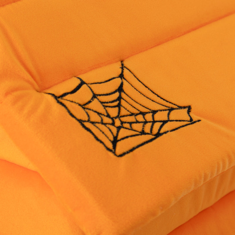 Orange cushion with a black spider web design on an orange background