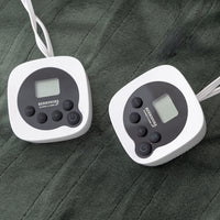 Two digital temperature controllers on a textured dark surface