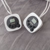 Two digital thermometers on a grey blanket surface