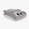 Gray electric blanket with two controllers on a white background