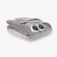 Gray electric blanket with two controllers on a white background