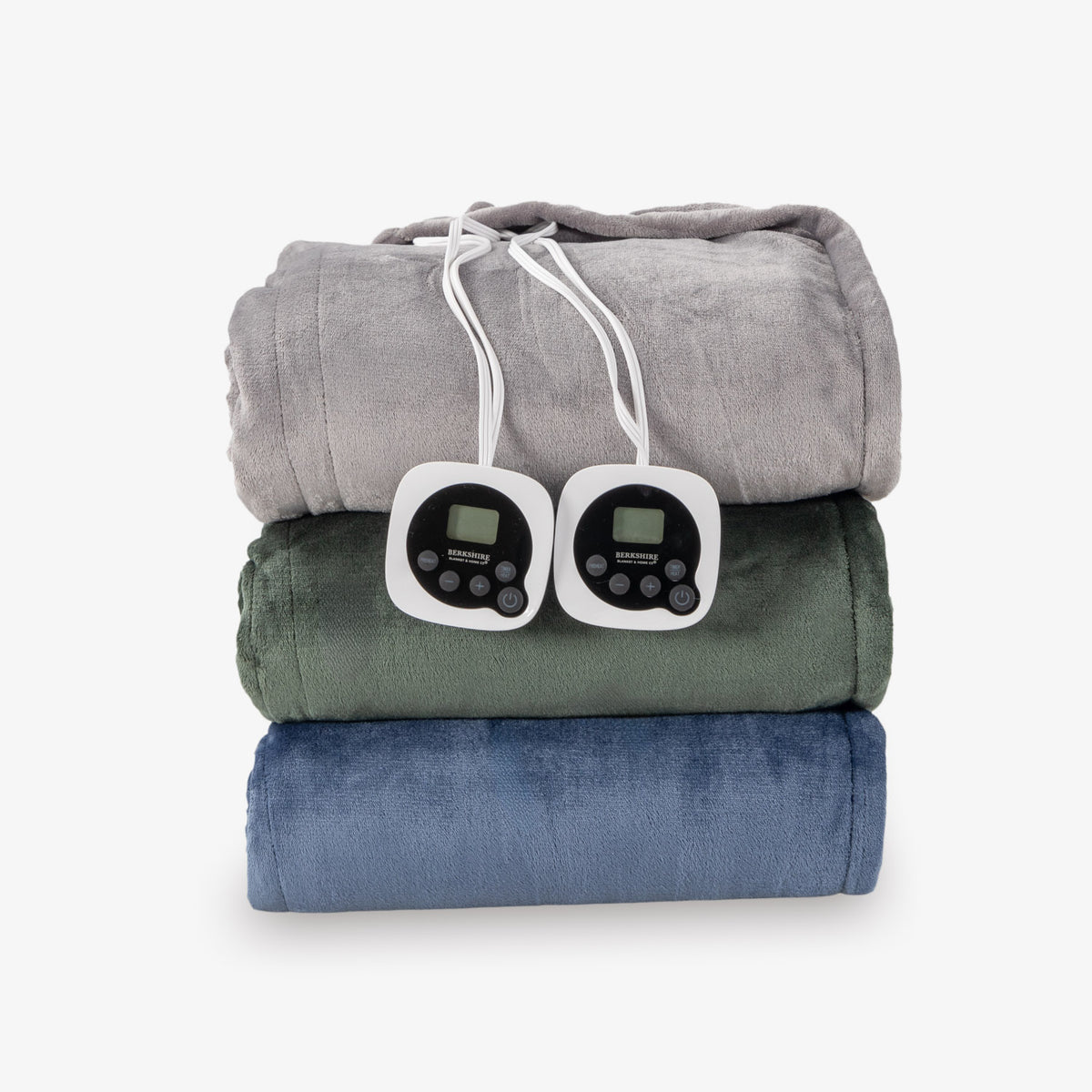 Stack of folded heated blankets with electric cords on a white background