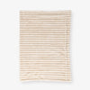 Beige textured throw laid flat on a white background