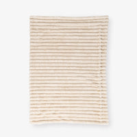 Beige textured throw laid flat on a white background
