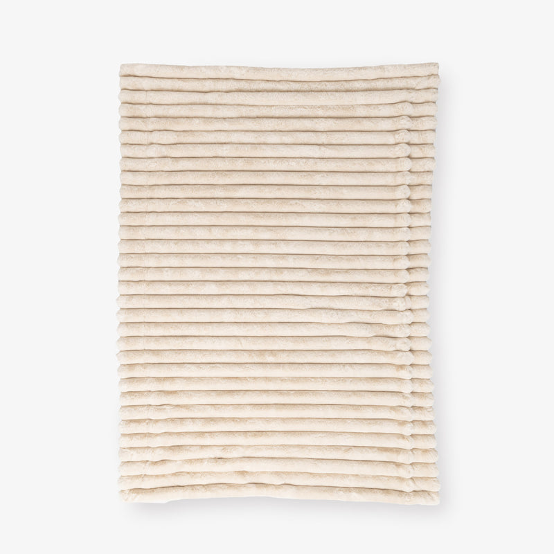 Beige textured throw laid flat on a white background
