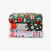 Stack of three colorful fabric swatches with festive patterns on a white background