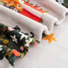 Close-up of folded fabric with floral and cat patterns on a white background