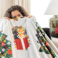 A women holding up a cat printed holiday throw.