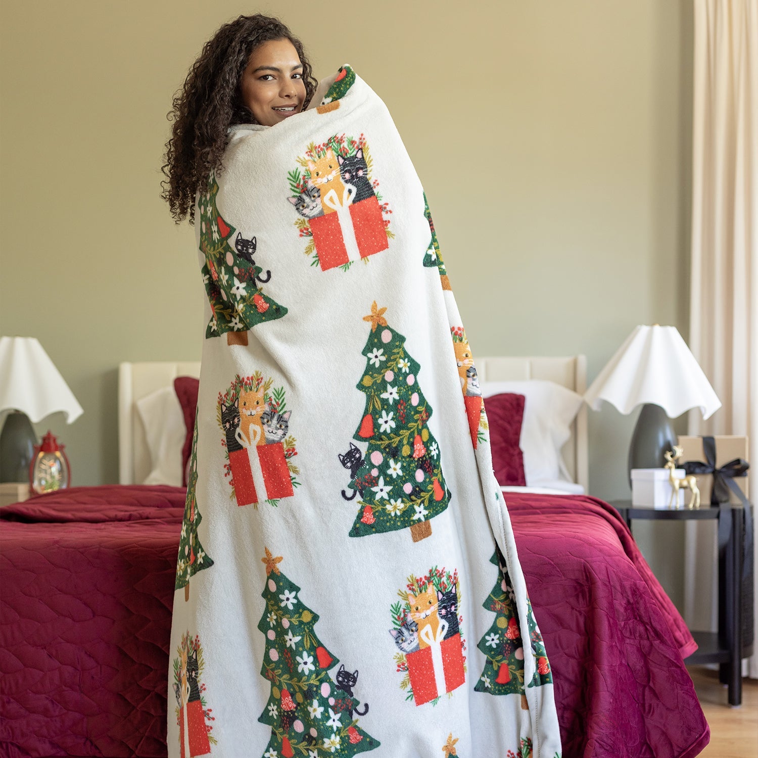 Cat printed holiday throw draped over a womans shoulders.