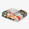 Folded blanket with animal and floral pattern on a white background