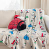 A snoopy holiday throw draped over a beige sofa.