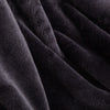 A close up of a black velvety plush throw displaying its silky plush texture.