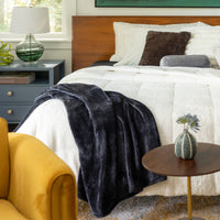 Our black VelvetLoft Throw draped over our VelvetLoft Sherpa comforter set styled on a bed.