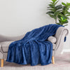 A blue velvety plush throw draped neatly over the arm of a light grey chair.