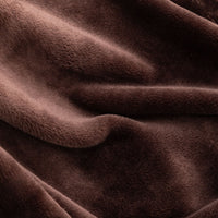 Close up of a brown velvety plush throw displaying its plush texture.