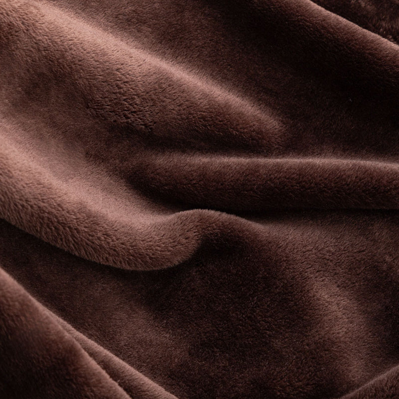 Close up of a brown velvety plush throw displaying its plush texture.