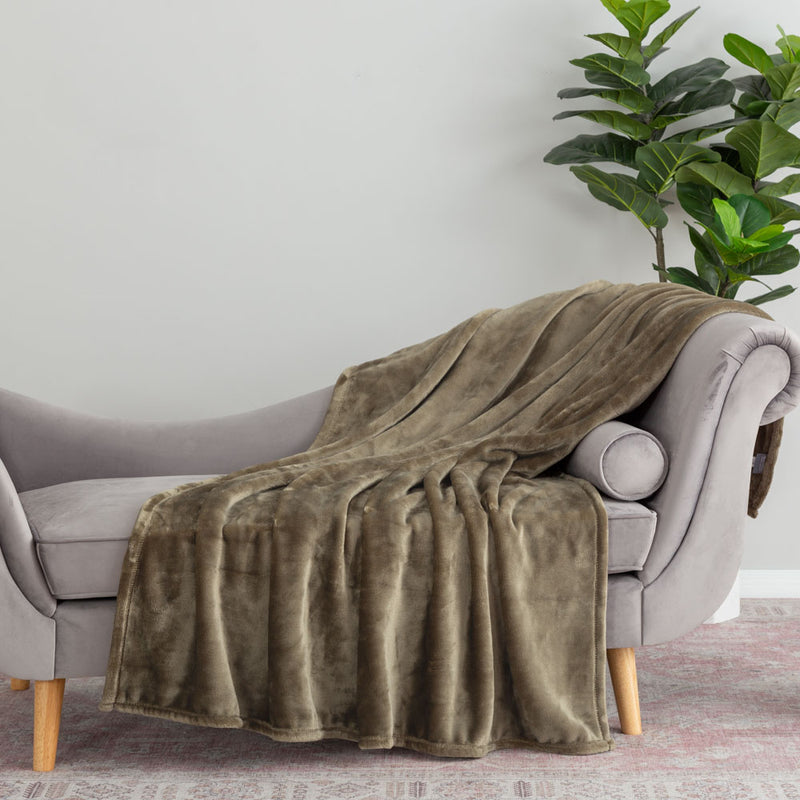 A green velvety throw draped neatly over a grey chair.