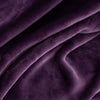 Close up of a purple velvety plush throw displaying its silky plush texture.