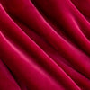 Close up of a neon pink velvety throw displaying its silky smooth and plush texture.