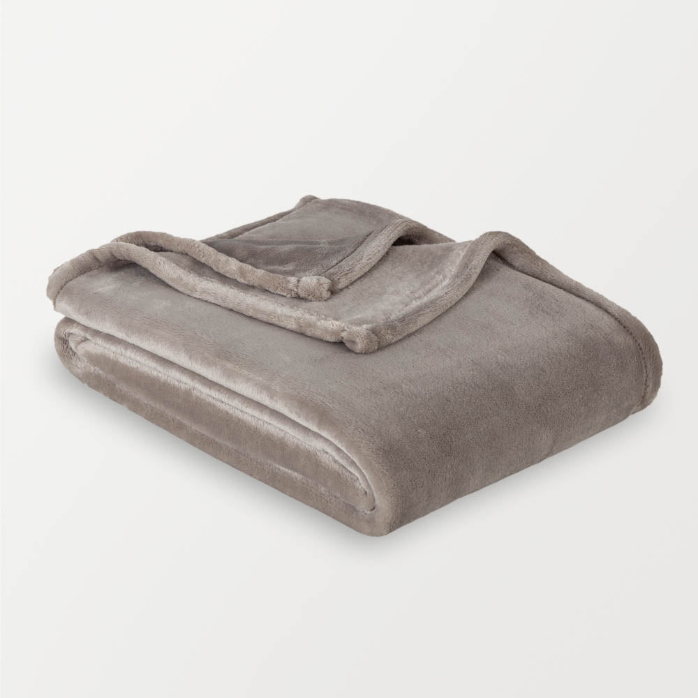 A grey velvety plush throw folded neatly on a white surface.