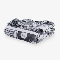 Folded black and white patterned blanket on a white background