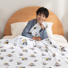 A child sitting with a white valentines peanuts throw.