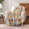 Halloween peanuts throw draped over a beige chair.