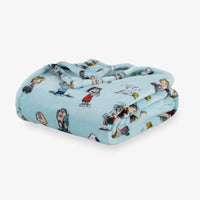 Folded blanket with cartoon character pattern on a light blue background
