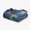 Folded denim blanket with rainbow and dog design on a white background