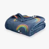 Folded denim blanket with rainbow and dog design on a white background
