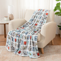 A blue and grey snoopy block throw draped neatly over a beige leather chair.