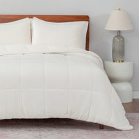 Neatly made bed with white bedding in a bedroom setting.
