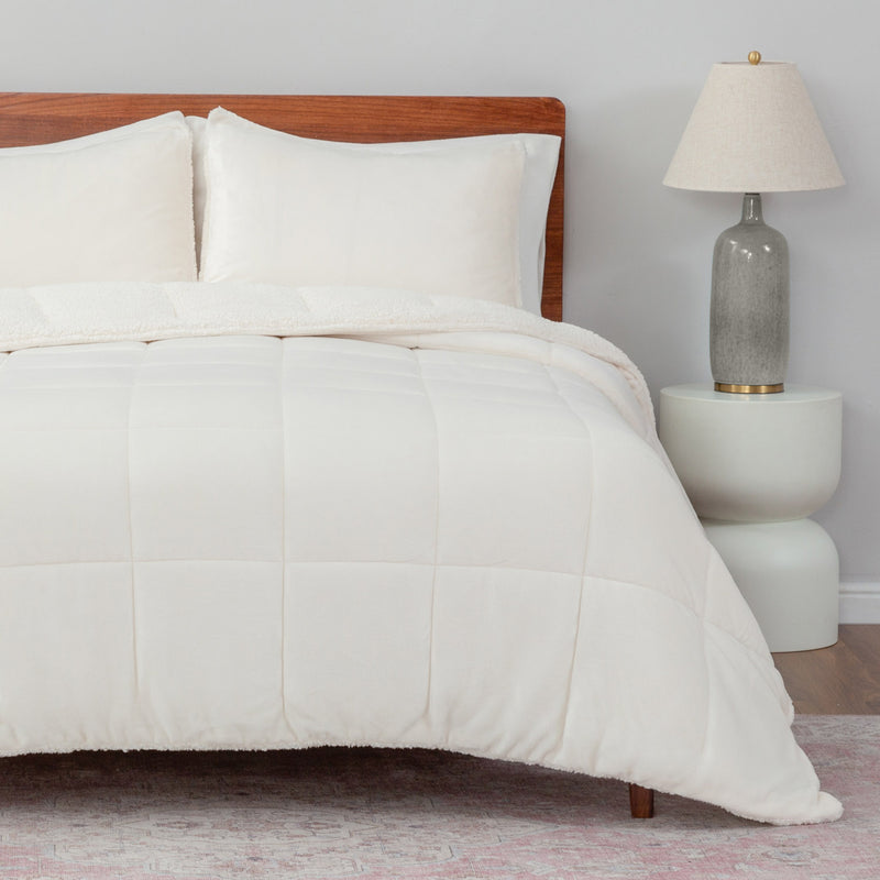 Neatly made bed with white bedding in a bedroom setting.