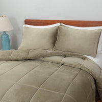 A green quilted comforter draped over a bed with matching green pillows.