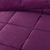 A close-up of a purple quilted comforter showcasing its stitching and soft texture.