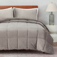 Gray comforter set on a bed with pillows and a lamp in the background