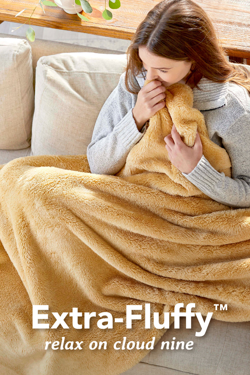 Image of a woman snuggling a yellow/orange Extra-Fluffy™ throw on her couch. text reads: Extra-Fluffy™ relax on cloud nice