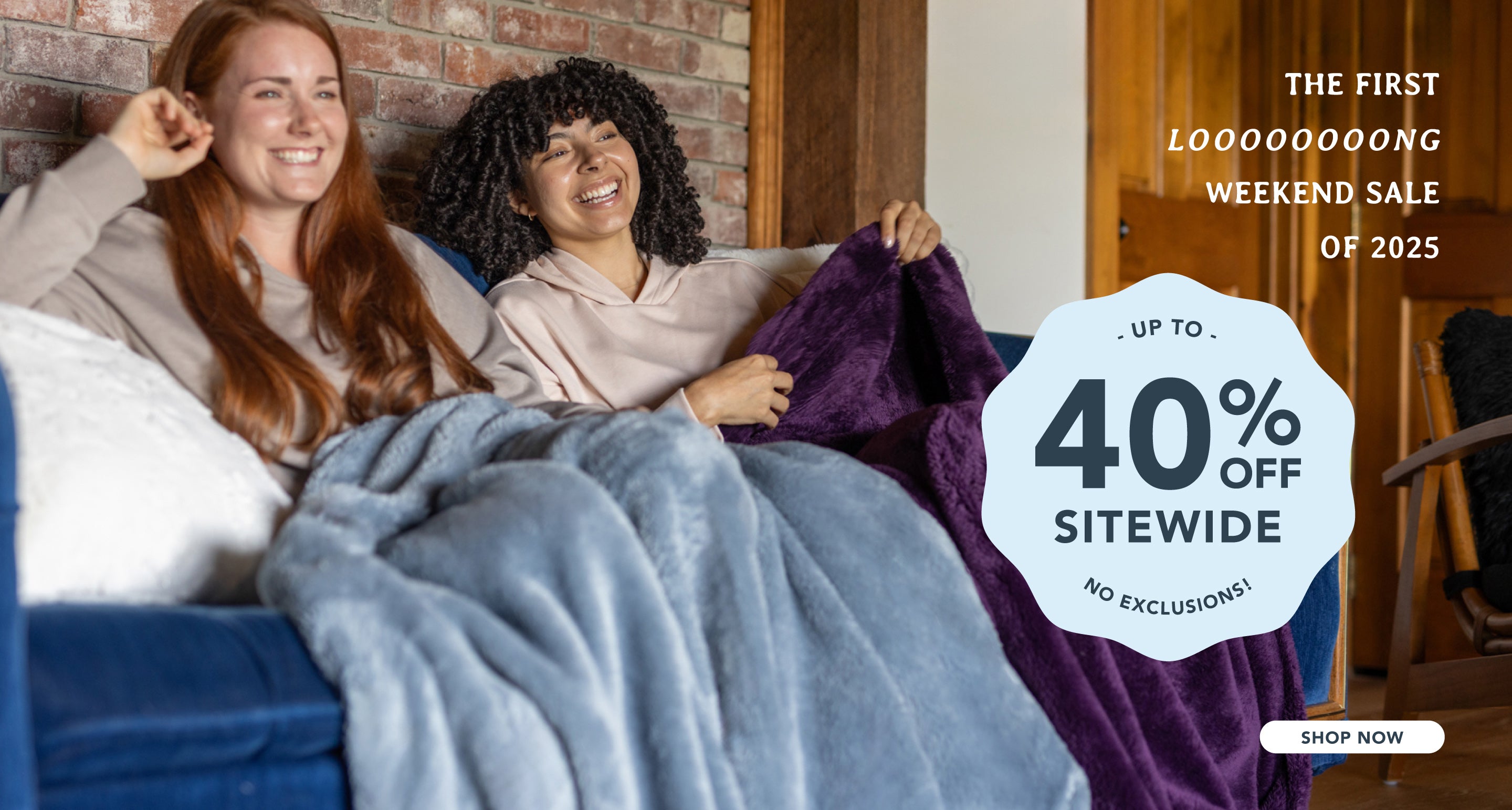 The first looooooong weekend sale of 2025, up to 40% off sitewide, no exclusions with two women sitting on a blue sofa with our Extra-Fluffy Throws draped over their legs. 