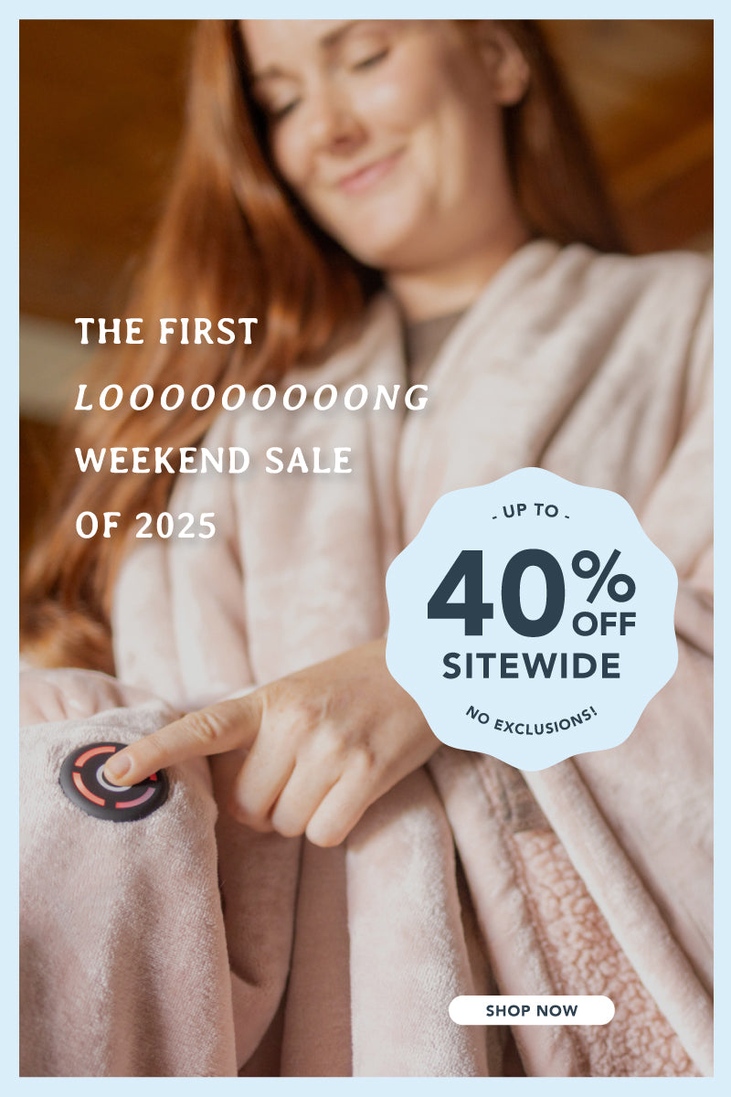 The first looooooong weekend sale of 2025, up to 40% off sitewide, no exclusions with a woman standing up pressing our EZ touch button on our pink Heated Wearable Throw.