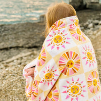 Vicky Yorke Summer Nostalgia beach towel worn around someone's shoulders.